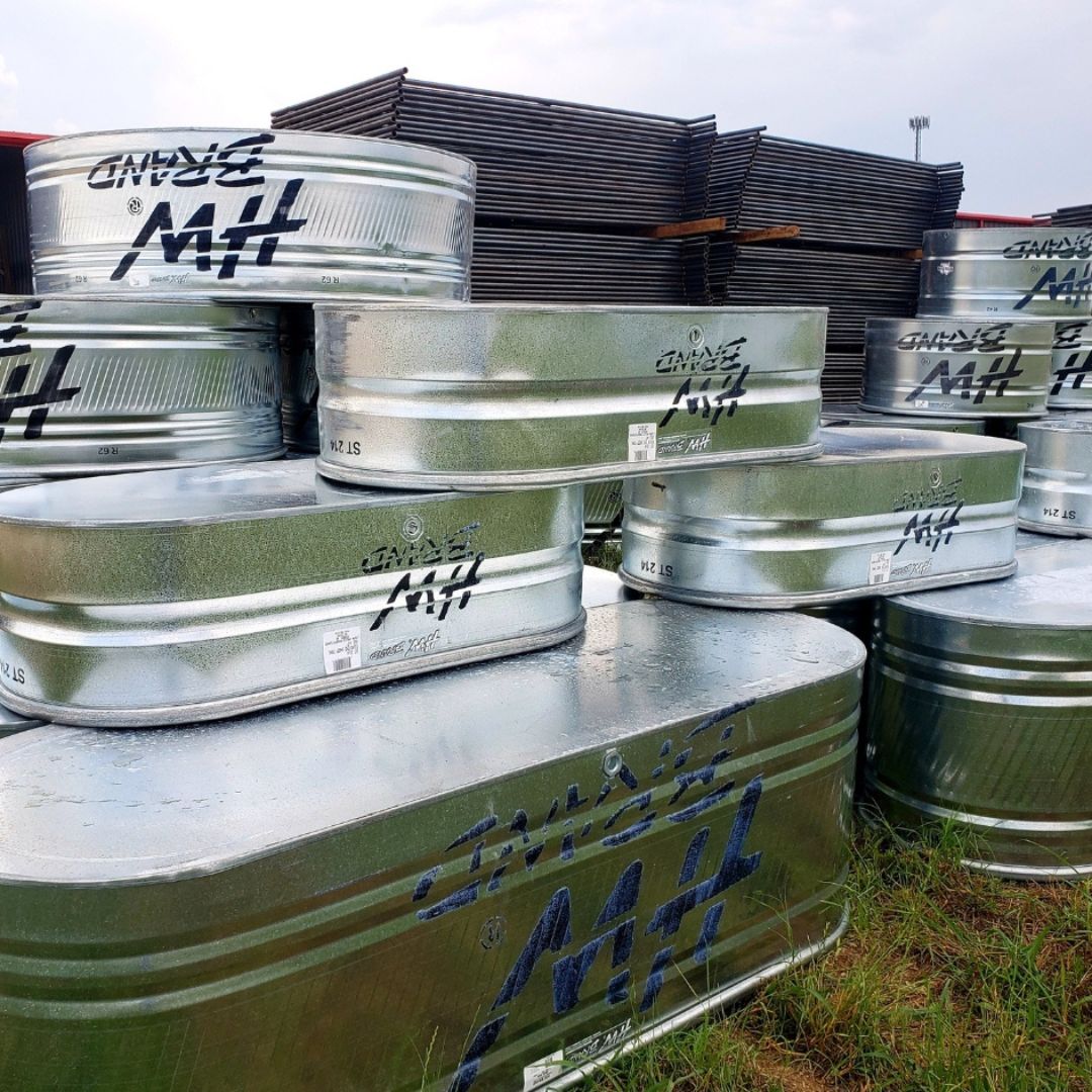 Stacks of stock tanks in front of livestock fencing