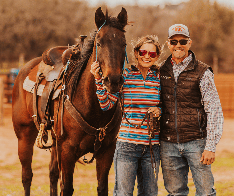 Couple standing with horse outdoors wearing casual clothing