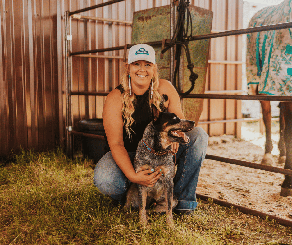 woman with dog in barn smiling