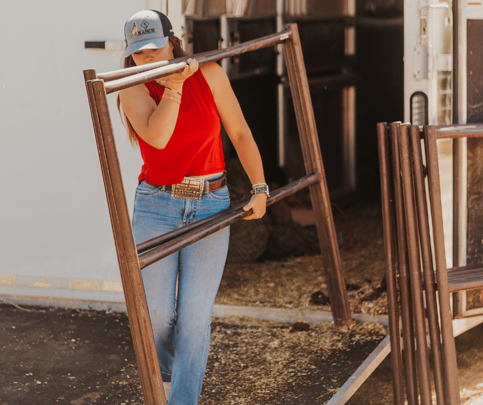 person carrying metal bars wearing red shirt and cap