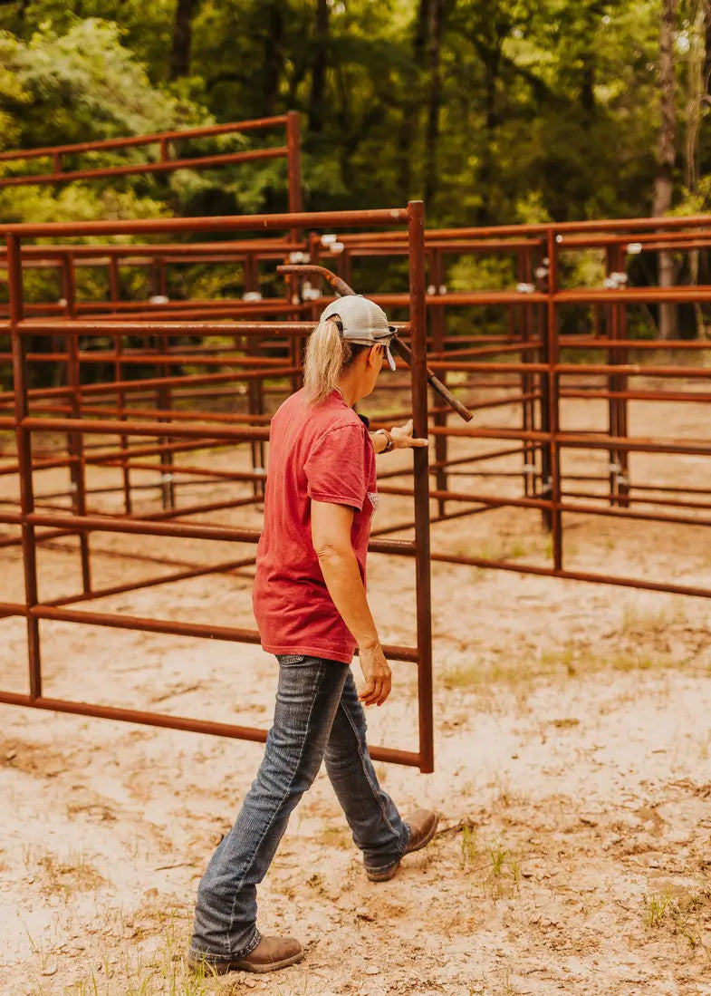 Woman in a red shirt closing a 6 rail gate