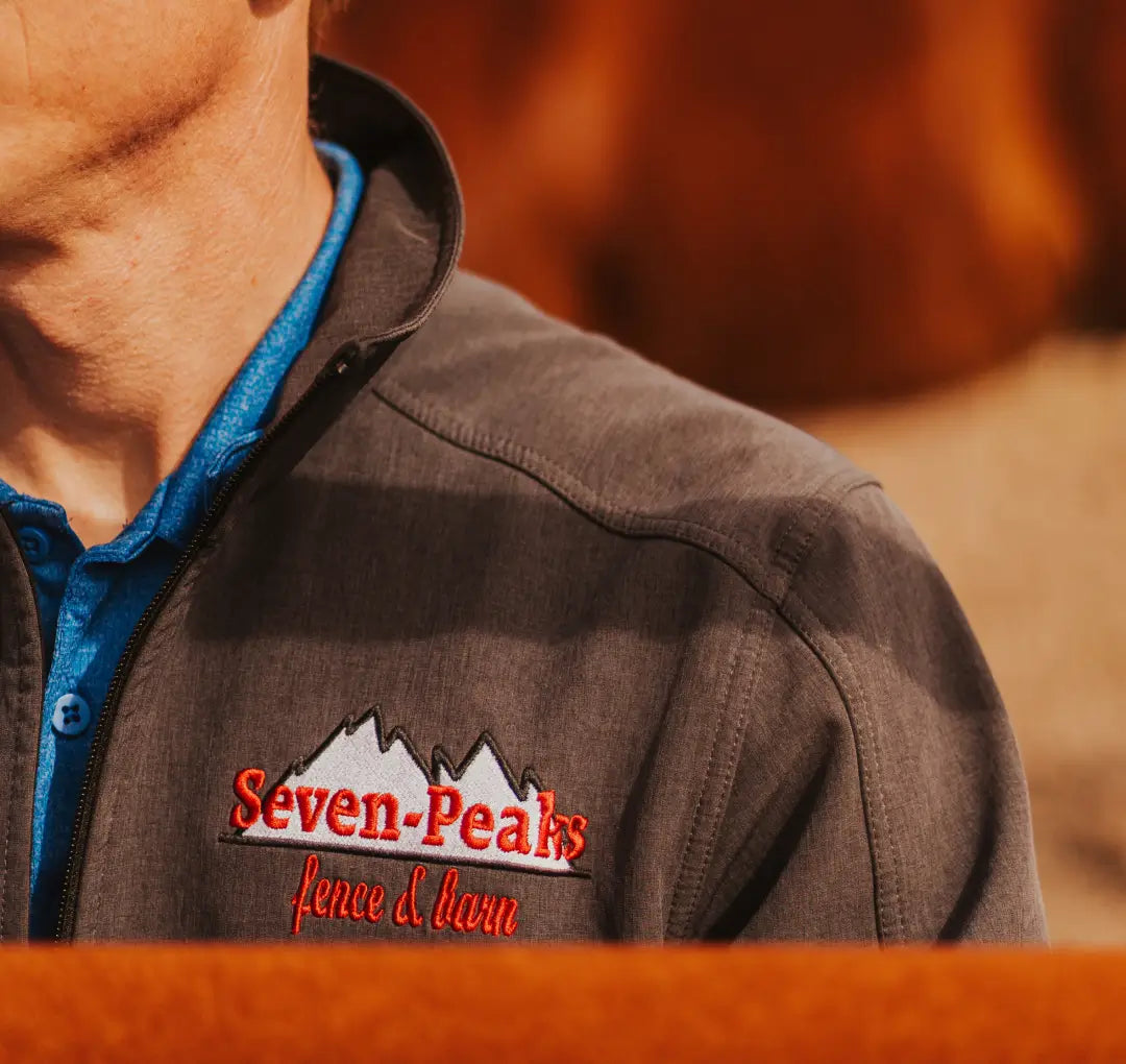 close up of man in brown jacket with seven peaks logo